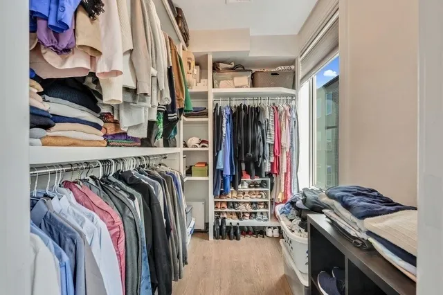 a view of walk in closet with clothes and shoes