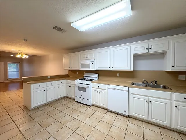 a kitchen with white cabinets appliances and a sink