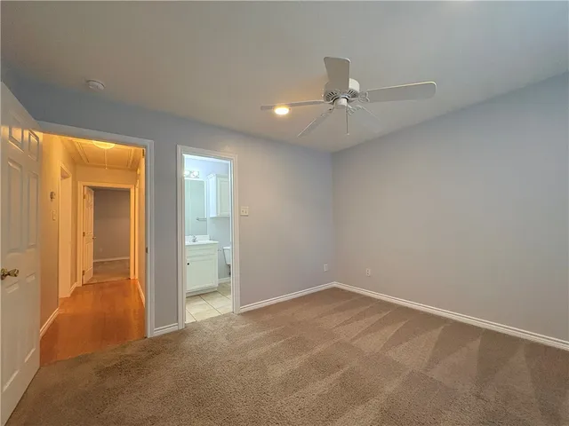 an empty room with closet and a chandelier fan