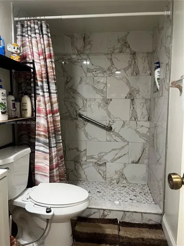 a bathroom with a toilet and shower