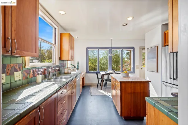 a kitchen with stainless steel appliances kitchen island granite countertop a stove top oven a sink dishwasher and cabinets with wooden floor