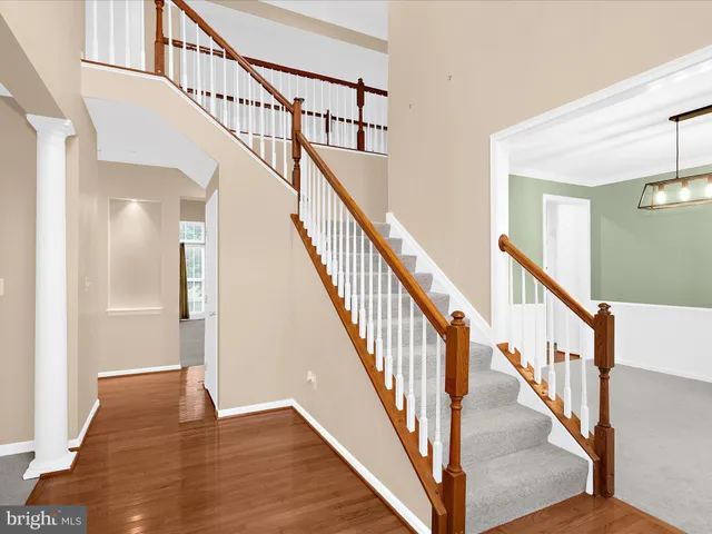 a view of staircase with wooden floor and white walls