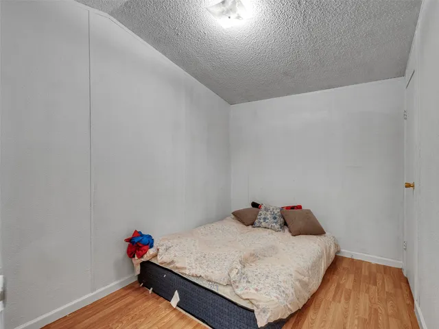 a bedroom with a bed and wooden floor