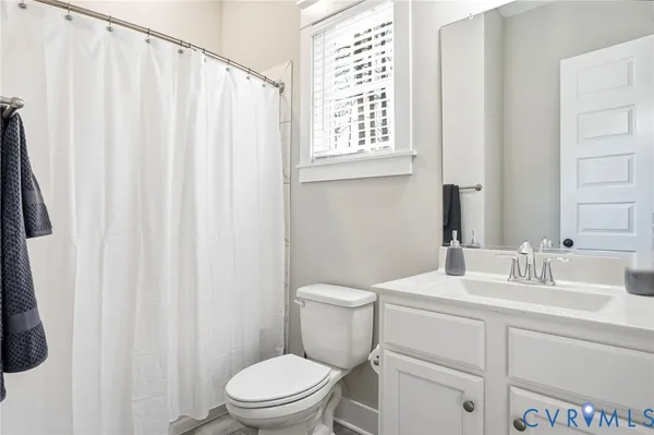 a bathroom with a sink a toilet and shower curtain