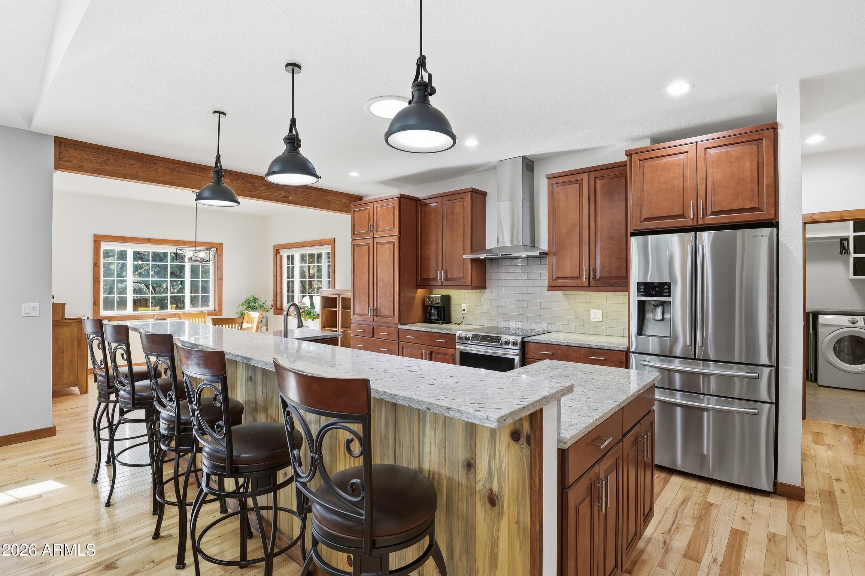 1703 West Dillon Way Payson, AZ 85541 - Photo 9 of 56 a kitchen with granite countertop a table chairs stainless steel appliances and wooden floor