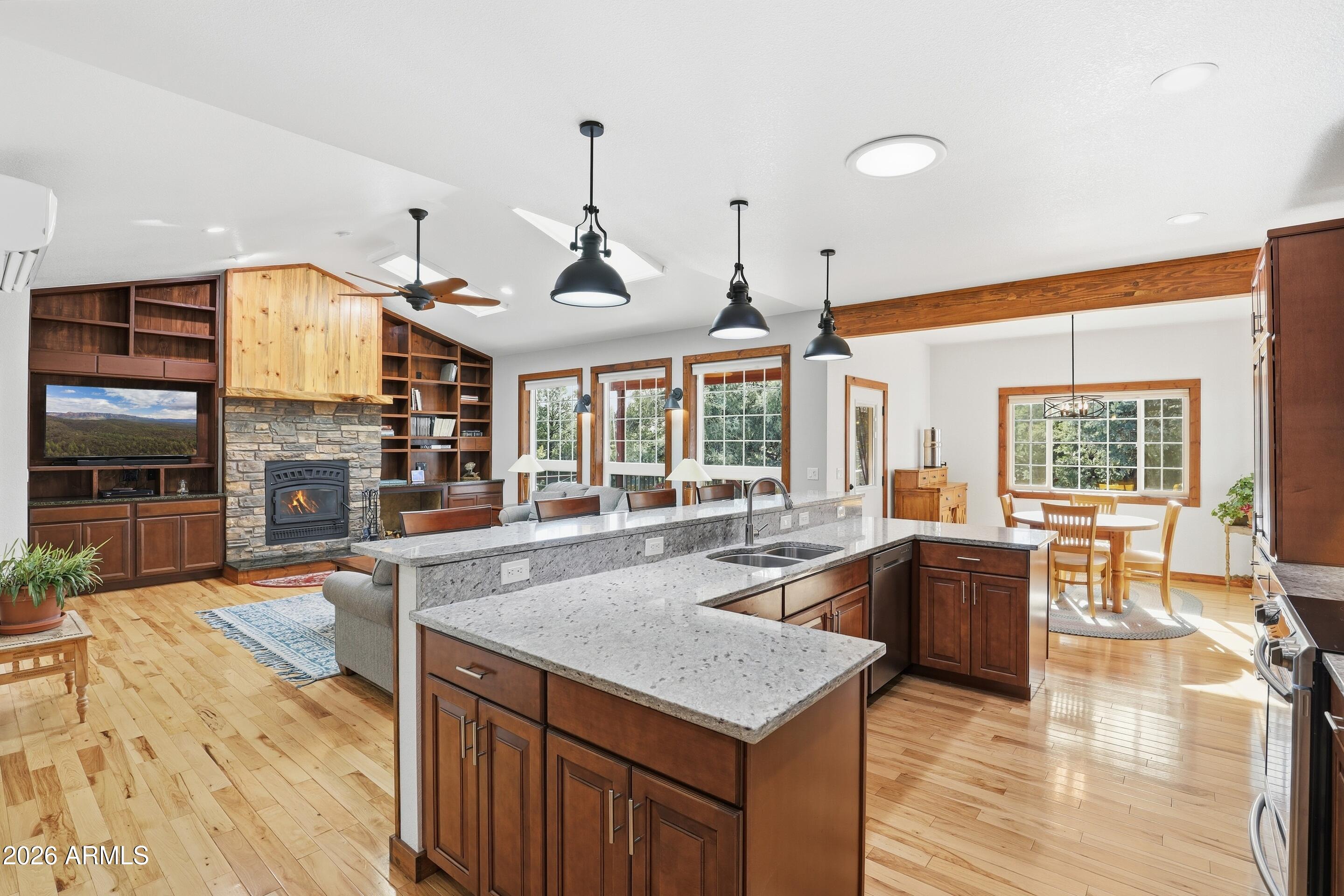 1703 West Dillon Way Payson, AZ 85541 - Photo 10 of 56 a large kitchen with stainless steel appliances granite countertop a large stove a sink dishwasher and a living room with couches bookshelf
