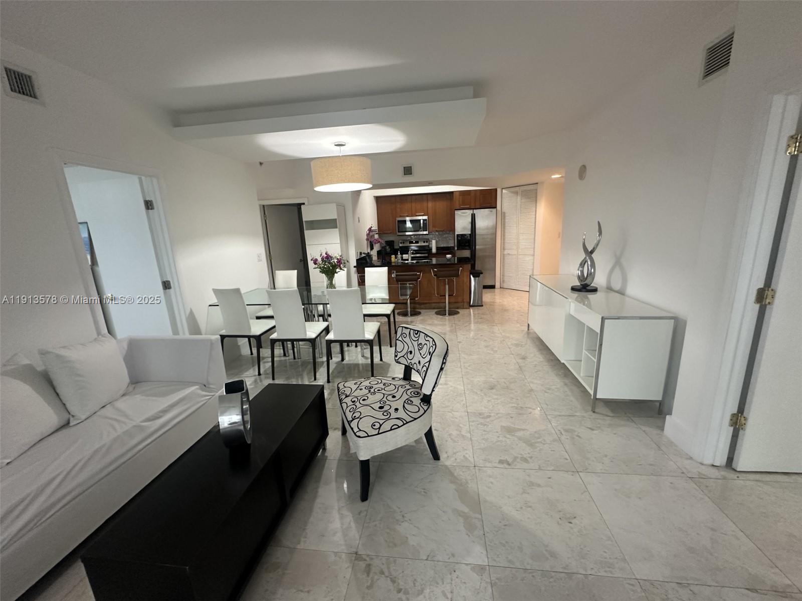 4100 Salzedo Street, Unit 704 Coral Gables, FL 33146 - Photo 12 of 25 a living room with furniture and a chandelier