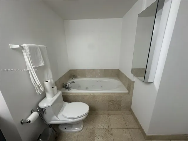 a bathroom with a granite countertop toilet and a sink