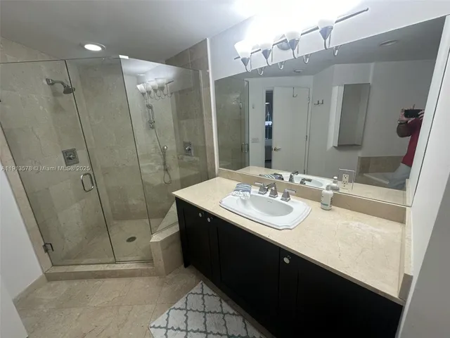 a bathroom with a sink a mirror and a shower