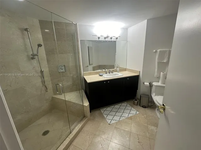 a bathroom with a sink mirror and shower