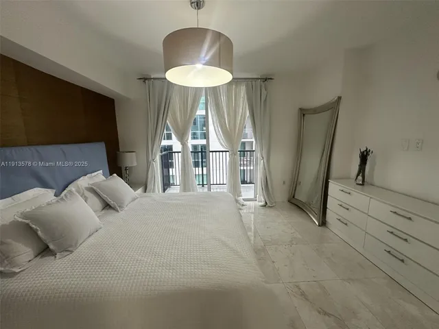 a bed room with a bed and a chandelier