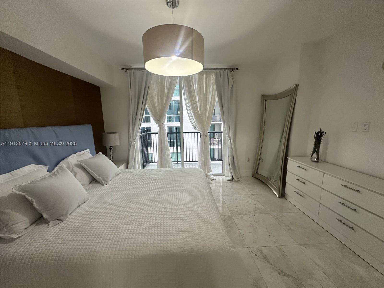 4100 Salzedo Street, Unit 704 Coral Gables, FL 33146 - Photo 20 of 25 a bed room with a bed and a chandelier