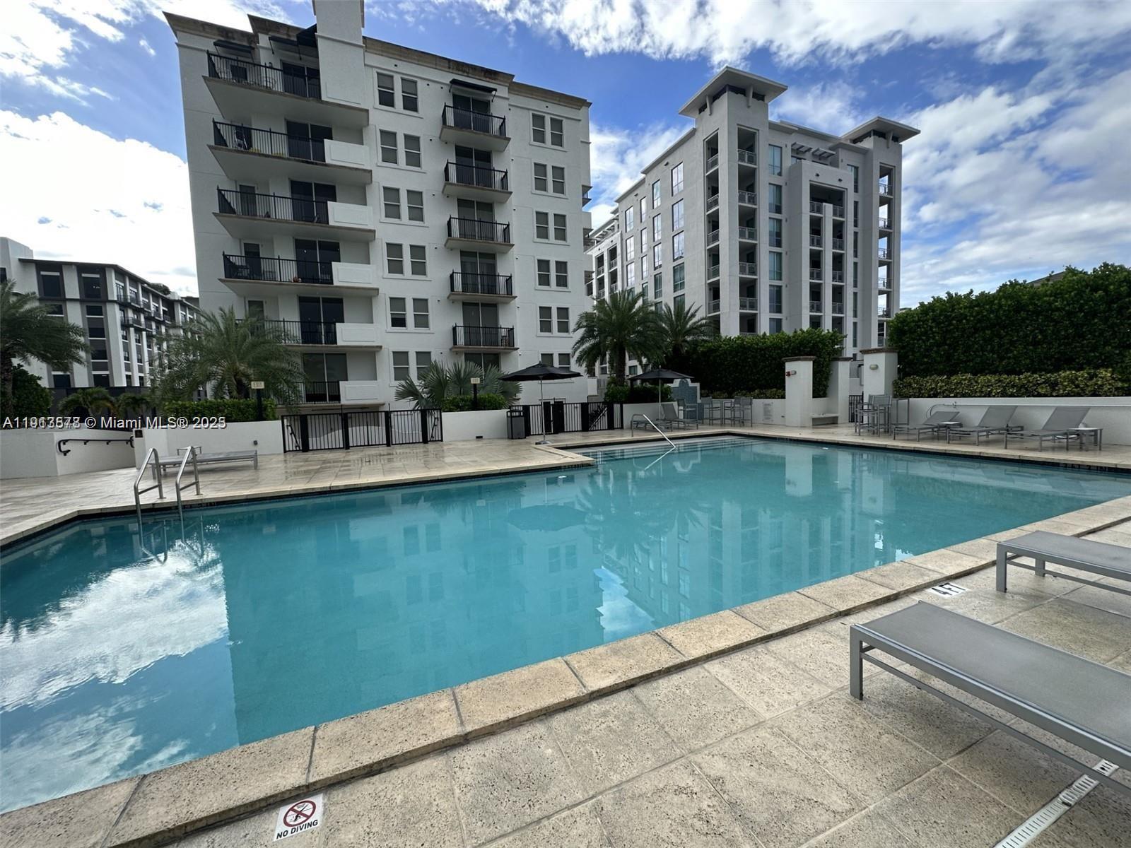 4100 Salzedo Street, Unit 704 Coral Gables, FL 33146 - Photo 2 of 25 a view of swimming pool with outdoor seating and lake view