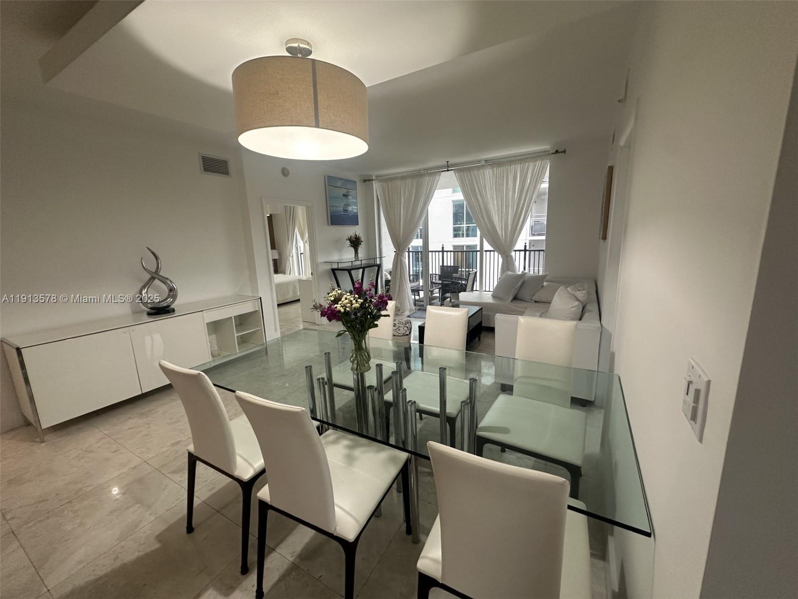 4100 Salzedo Street, Unit 704 Coral Gables, FL 33146 - Photo 22 of 25 a view of a dining room with furniture and a chandelier