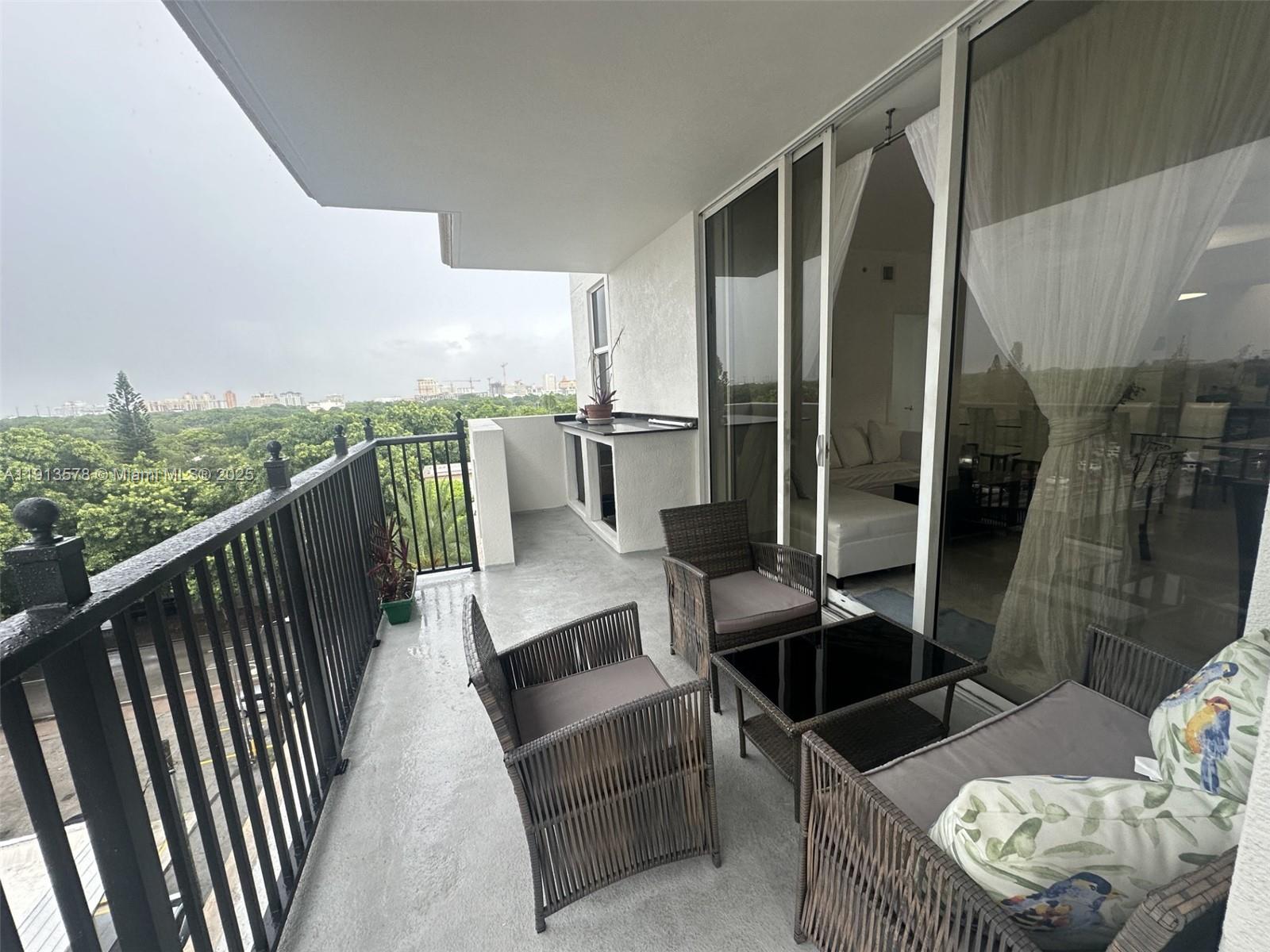 4100 Salzedo Street, Unit 704 Coral Gables, FL 33146 - Photo 6 of 25 a balcony with furniture and a floor to ceiling window