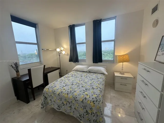 a bedroom with a bed a couch and dresser