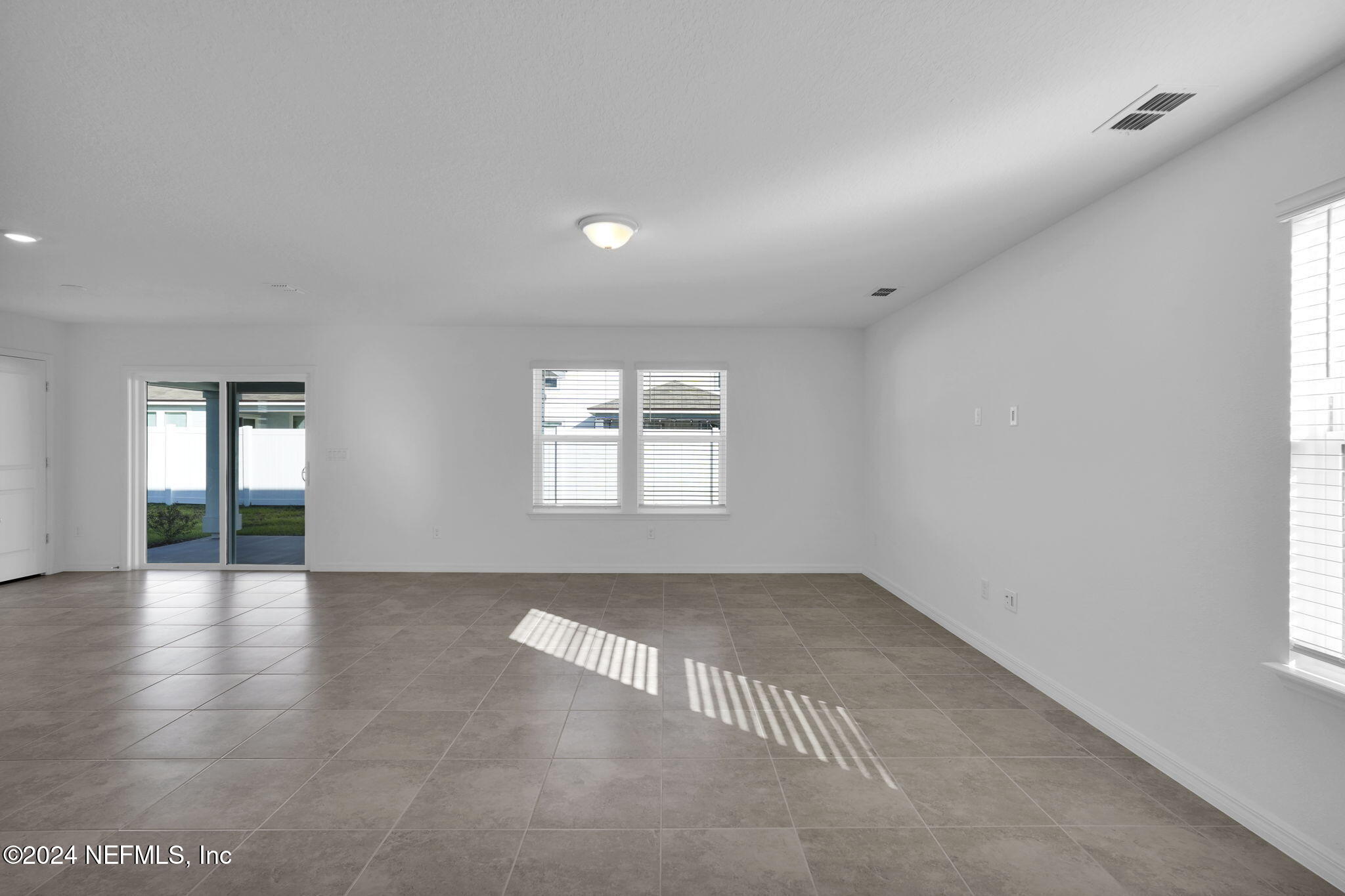5441 Integrity Way Jacksonville, FL 32244 - Photo 12 of 38 an empty room with wooden floor and windows
