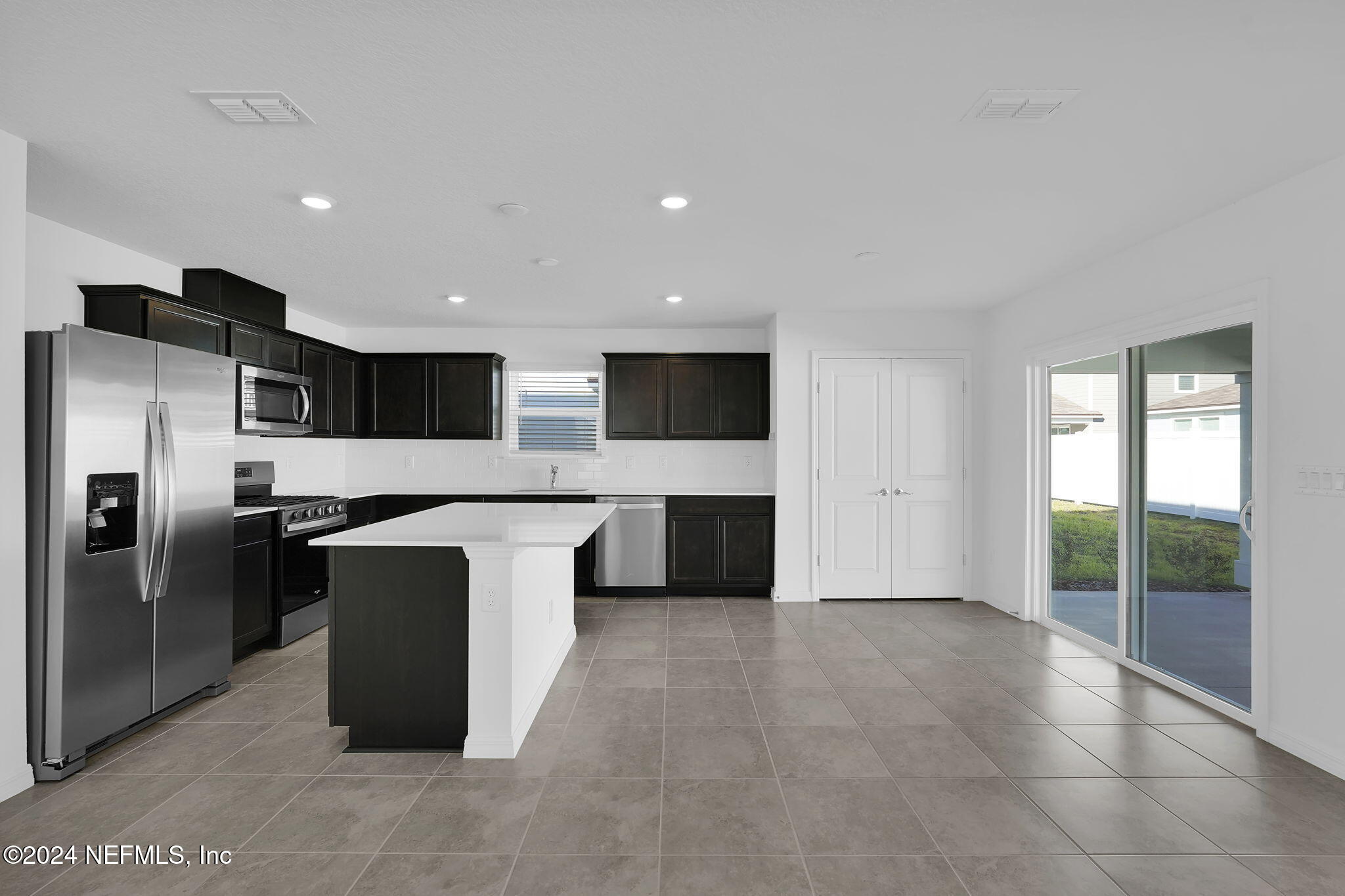 5441 Integrity Way Jacksonville, FL 32244 - Photo 15 of 38 a large kitchen with stainless steel appliances kitchen island granite countertop a refrigerator and a sink
