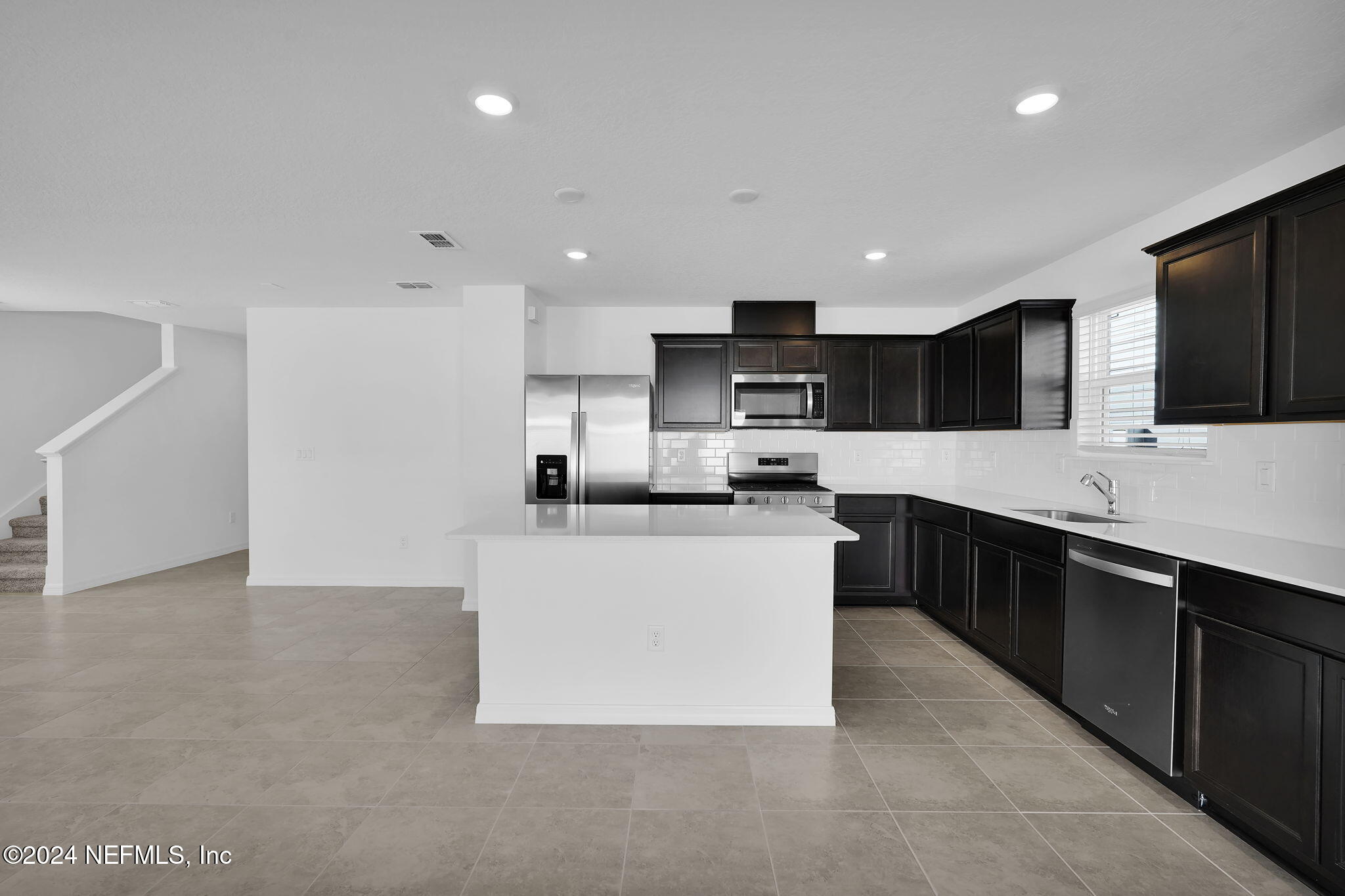 5441 Integrity Way Jacksonville, FL 32244 - Photo 18 of 38 a large kitchen with stainless steel appliances a sink a stove a microwave a center island and cabinets