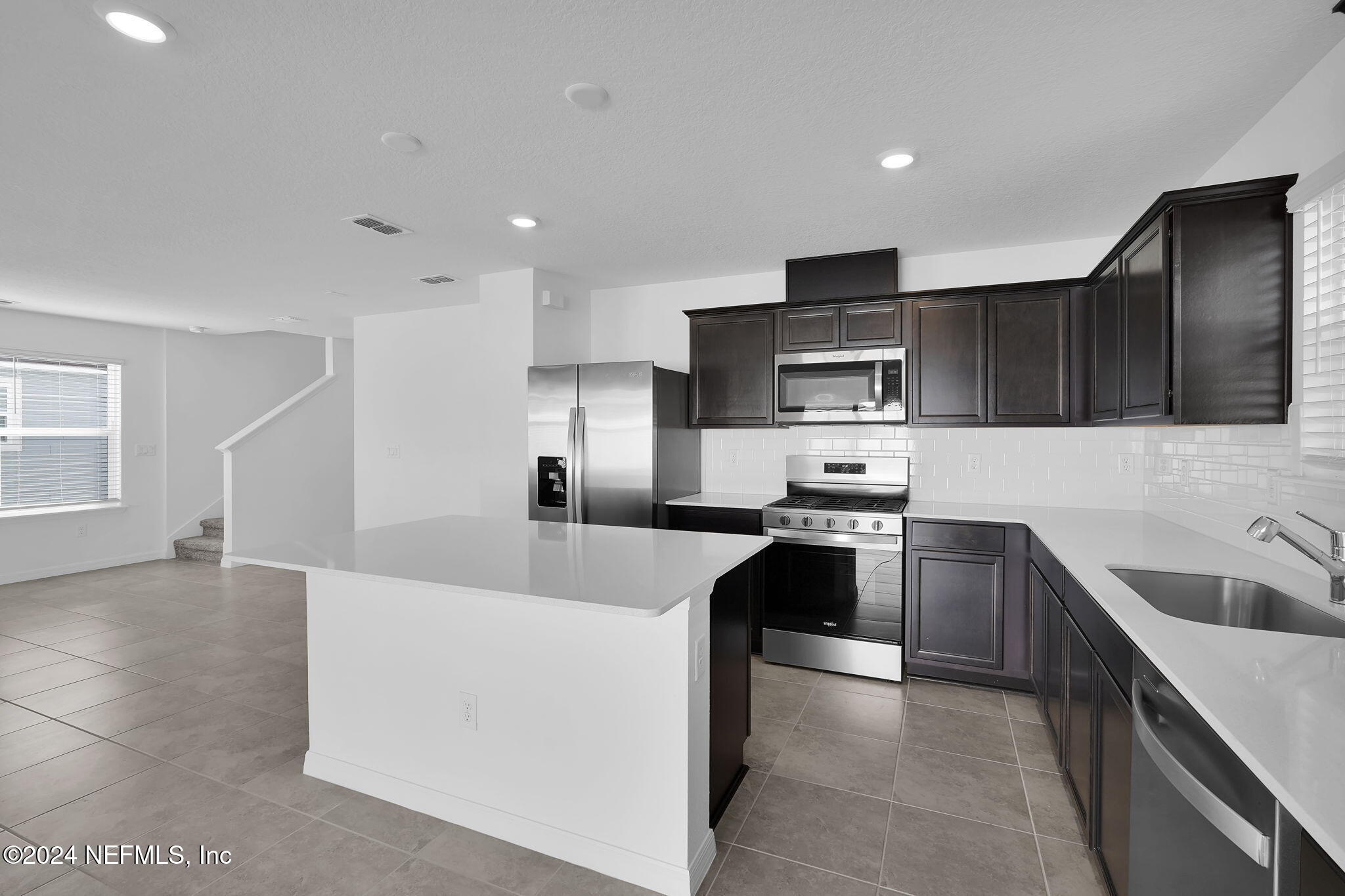 5441 Integrity Way Jacksonville, FL 32244 - Photo 19 of 38 a large kitchen with stainless steel appliances kitchen island granite countertop a sink dishwasher stove top oven and wooden cabinets