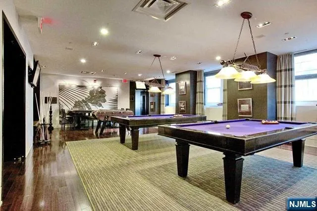 a room with pool table a wooden table and chairs