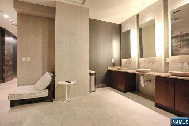 a large bathroom with a granite countertop tub sink and mirror