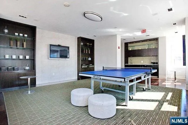 a living room with furniture a flat screen tv and kitchen view