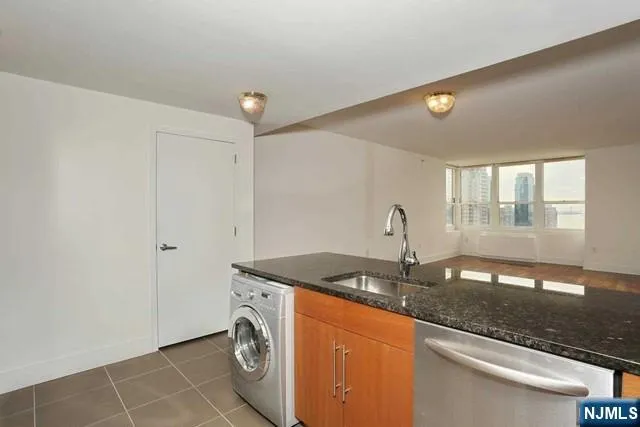 a utility room with granite countertop a sink and a vanity
