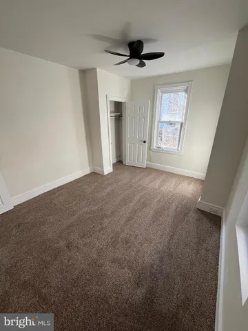 a view of empty room with wooden floor and window