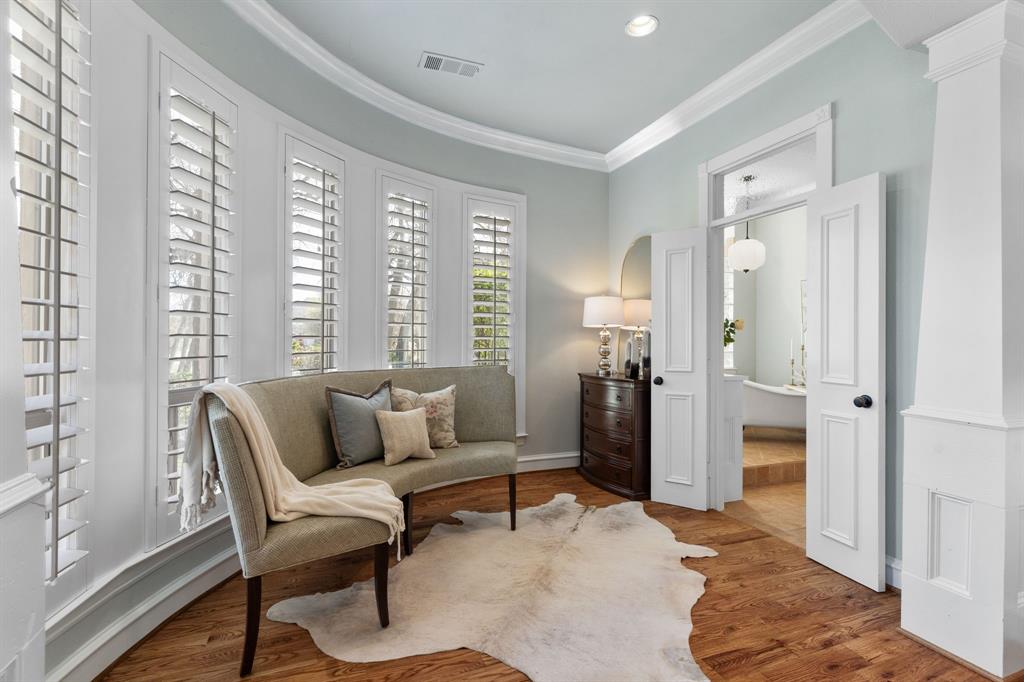 2404 Racheal Drive Heath, TX 75032 - Photo 20 of 40 Sitting area is encircled by a curved wall of windows with bespoke plantation shutters—ideal for morning coffee or quiet reading. French doors with a transom window lead to the sumptuous en suite bathroom