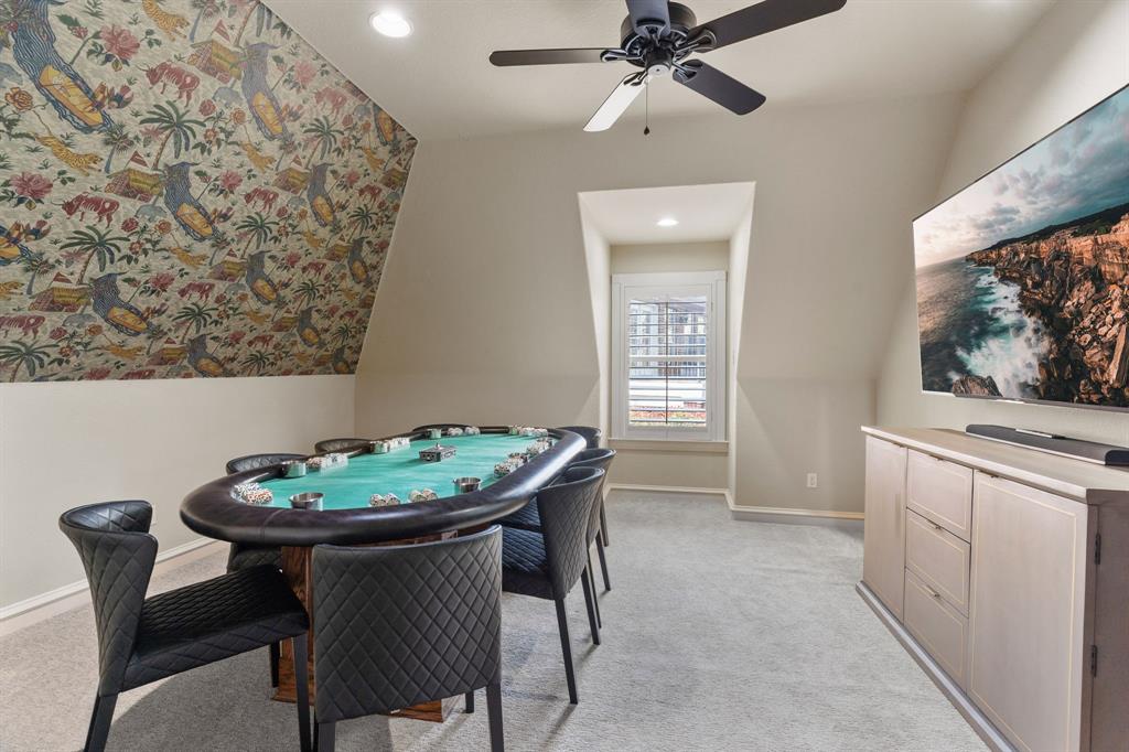 2404 Racheal Drive Heath, TX 75032 - Photo 30 of 40 Bedroom 4, currently staged as a game room, includes plush carpet, a chic wallpapered statement wall, a ceiling fan for year-round comfort, and a large walk-closet.