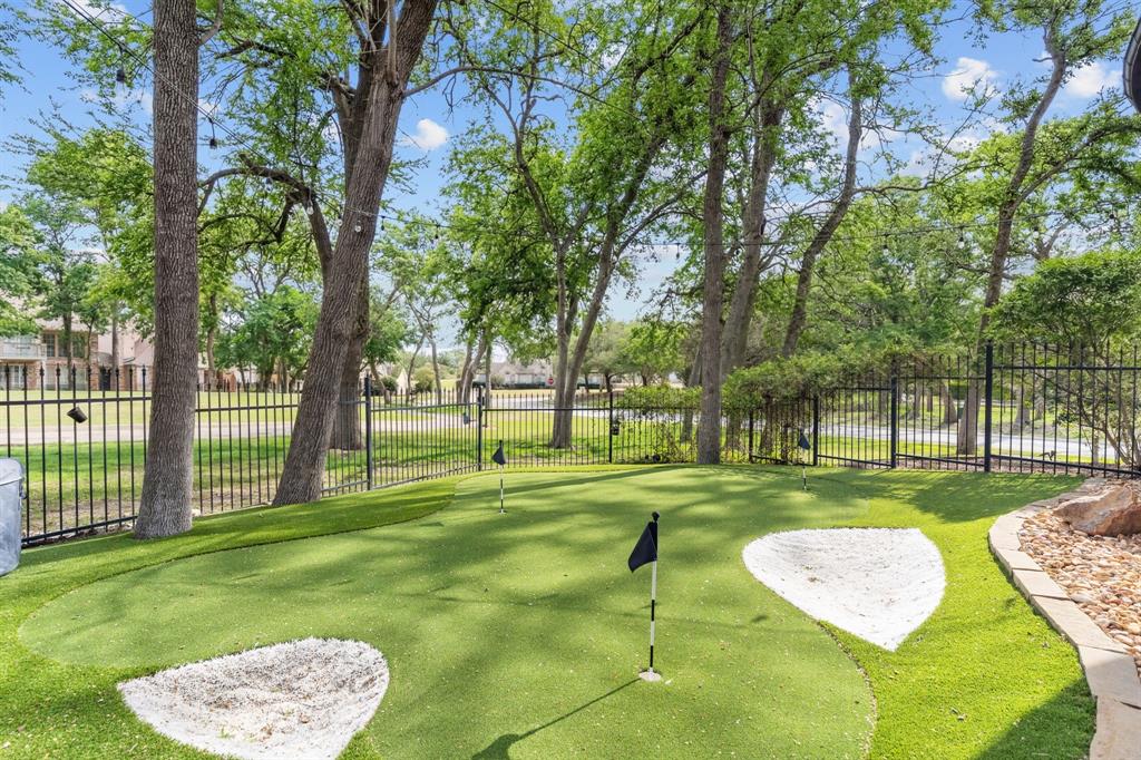 2404 Racheal Drive Heath, TX 75032 - Photo 36 of 40 Two private putting greens with “sand” traps, installed in 2024, offer the perfect setting to refine your short game, all while enjoying serene views of the 13th tee box at the championship course of Buffalo Creek Golf Club.