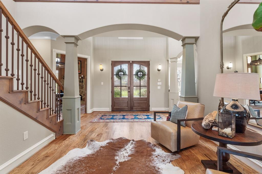 2404 Racheal Drive Heath, TX 75032 - Photo 6 of 40 The grand front entry welcomes you with newly refinished hand-scraped oak hardwood floors, framed by two elegant tapered columns with extensive millwork, that rise to a graceful archway, revealing a substantial Arhuas gold mirror in the front parlor, and a stunning wrought-iron staircase.