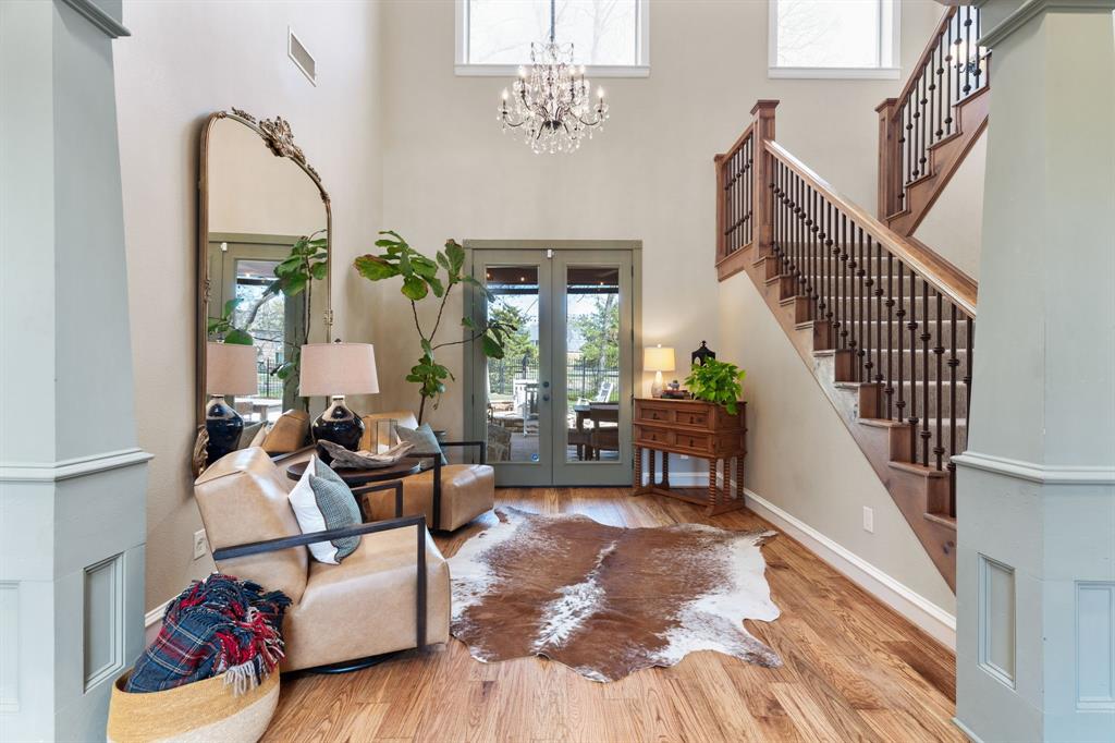 2404 Racheal Drive Heath, TX 75032 - Photo 7 of 40 The front parlor just off the front entry offers versatile use as a second living area or music room, offers a substantial gold-framed mirror, an ornate wrought iron crystal chandelier centering the room, and exterior glass French doors that open to the back porch, pool, and spa, creating seamless indoor-outdoor living.