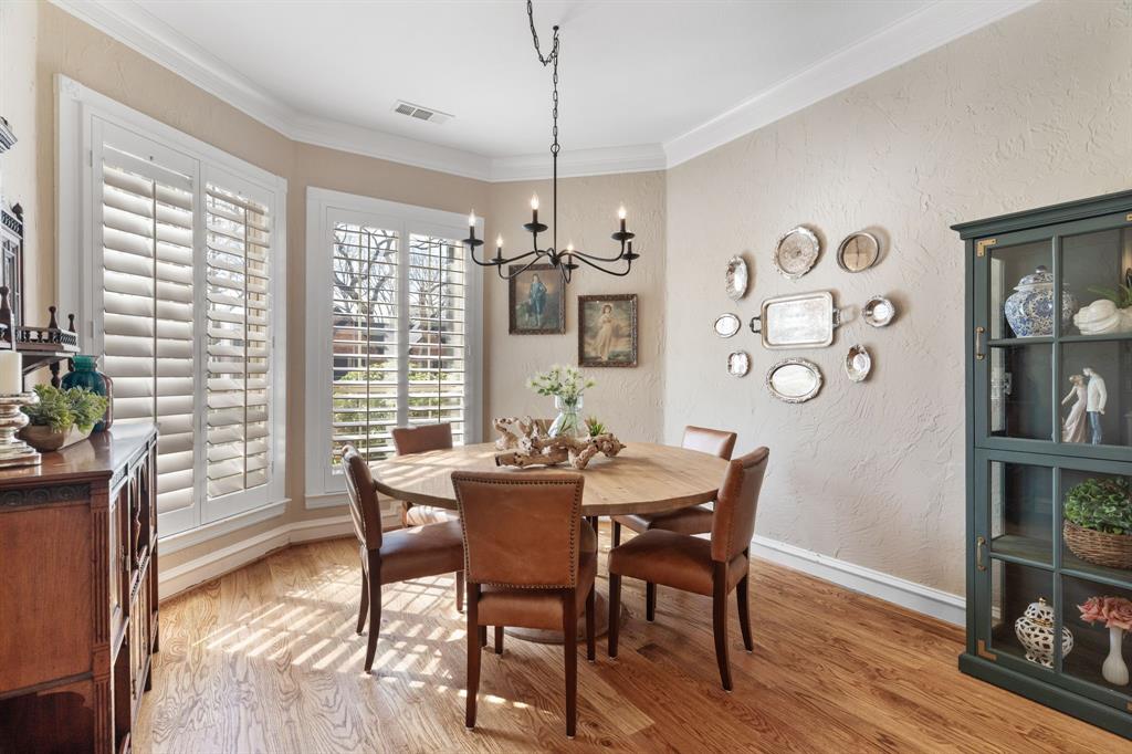 2404 Racheal Drive Heath, TX 75032 - Photo 9 of 40 The formal dining room features rich hardwood floors, 6-inch baseboards, and luxurious crown molding, while two large windows with plantation shutters frame views of the front yard. A tasteful Pottery Barn wrought-iron chandelier anchors the space, perfectly defining the area for a dining table to host dinner parties and holiday meals.