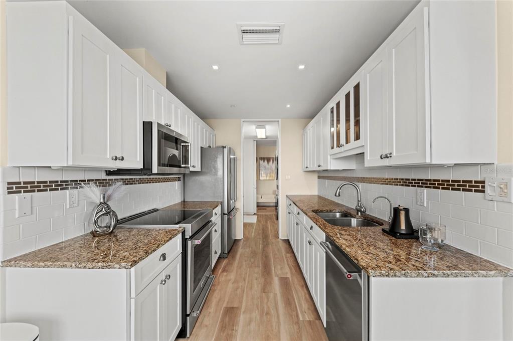 350 Golden Gate Point, Unit 61 Sarasota, FL 34236 - Photo 22 of 48 a kitchen with stainless steel appliances granite countertop a sink stove and refrigerator