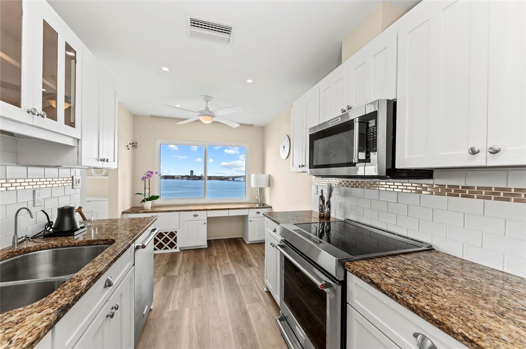 350 Golden Gate Point, Unit 61 Sarasota, FL 34236 - Photo 24 of 48 a kitchen with granite countertop a sink a counter top space appliances and cabinets