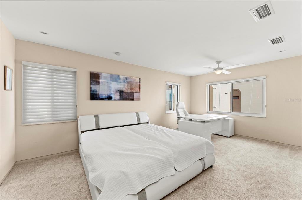350 Golden Gate Point, Unit 61 Sarasota, FL 34236 - Photo 25 of 48 a bedroom with a bed and a large window