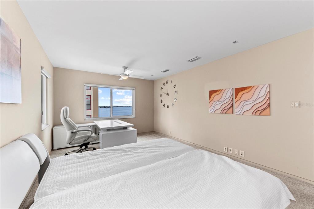 350 Golden Gate Point, Unit 61 Sarasota, FL 34236 - Photo 29 of 48 a bedroom with a large bed and wooden floor