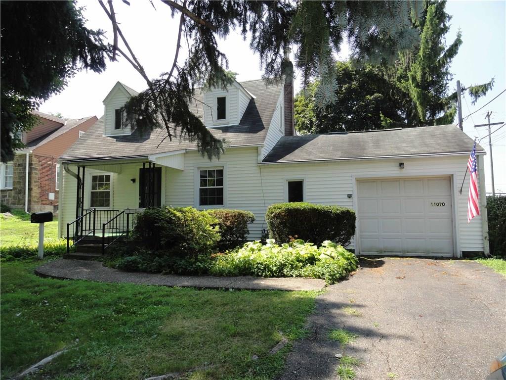 Vinyl sided Cape Cod on corner lot with attached garage.