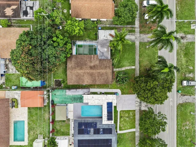an aerial view of a house with a garden and trees