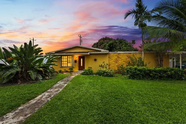 a front view of a house with a garden