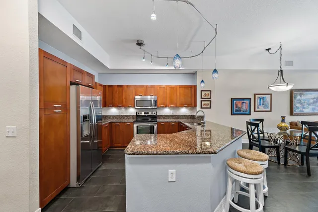 a kitchen with stainless steel appliances granite countertop a refrigerator stove and microwave