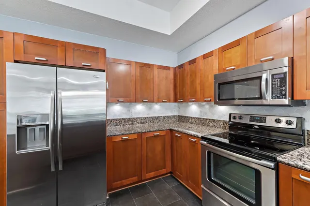 a spacious bathroom with a granite countertop sink a mirror and shower