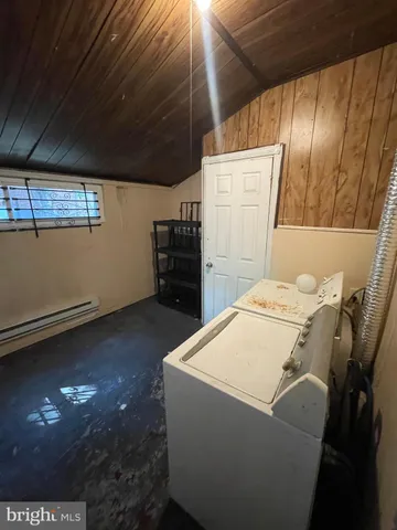 a room with water heater and wooden cabinets