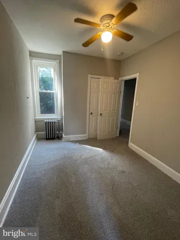 a view of a livingroom with a ceiling fan and window