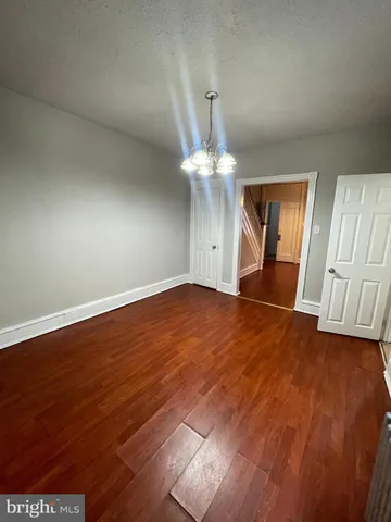 an empty room with wooden floor and staircase