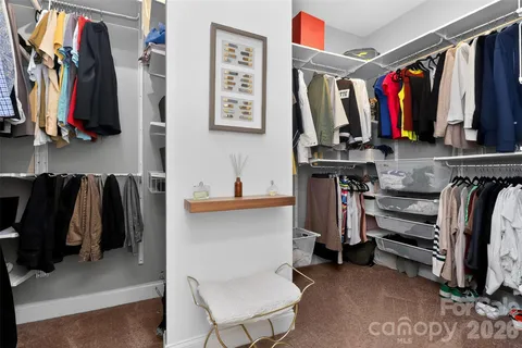 a view of walk in closet with clothes and shoes