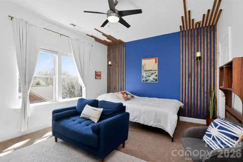 a bedroom with a bed couch and a window