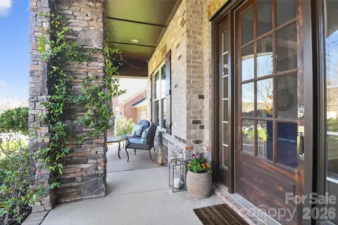 a view of a balcony with chairs potted plants